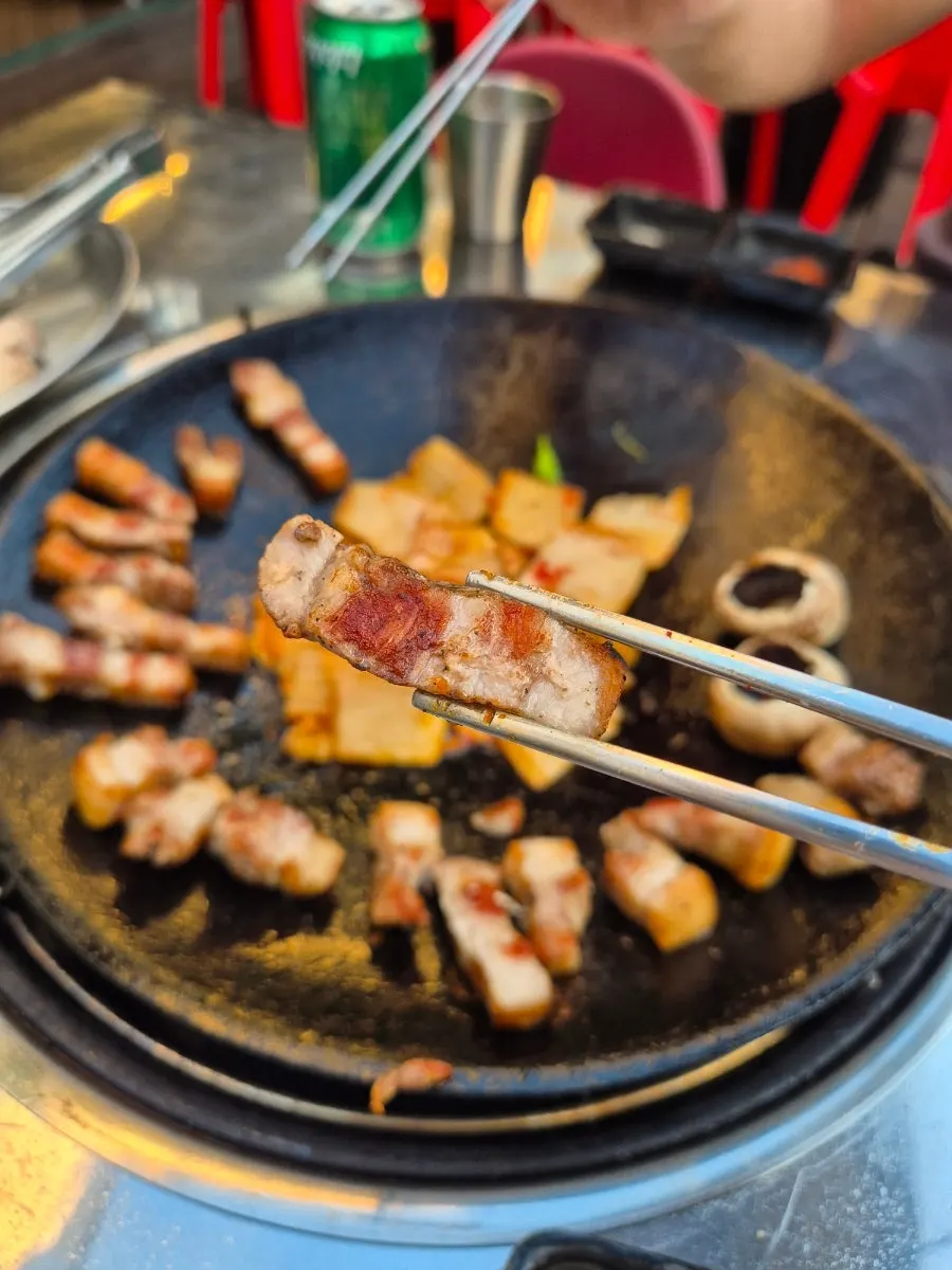 앞접시에 담긴 삼겹살과 곁들임 밑반찬