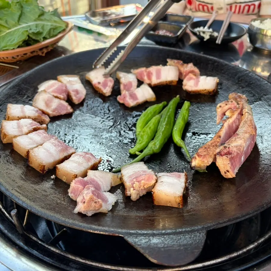 Bone-in pork belly being grilled tableside