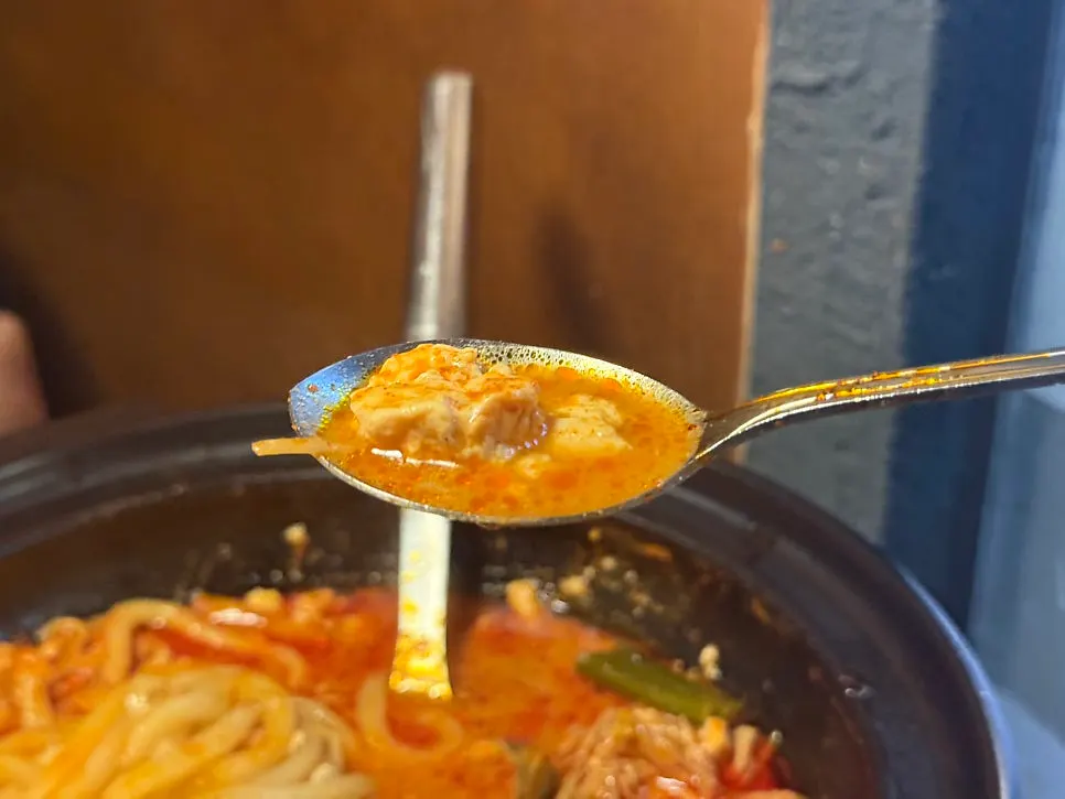 Beef tripe sundubu jeongol topped with bean sprouts and enoki mushrooms