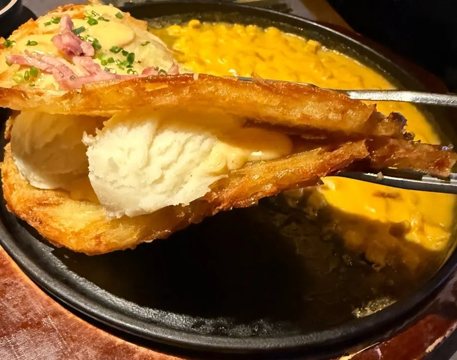 ポテトチヂミにとろりとしたチーズソースをつけた一切れ