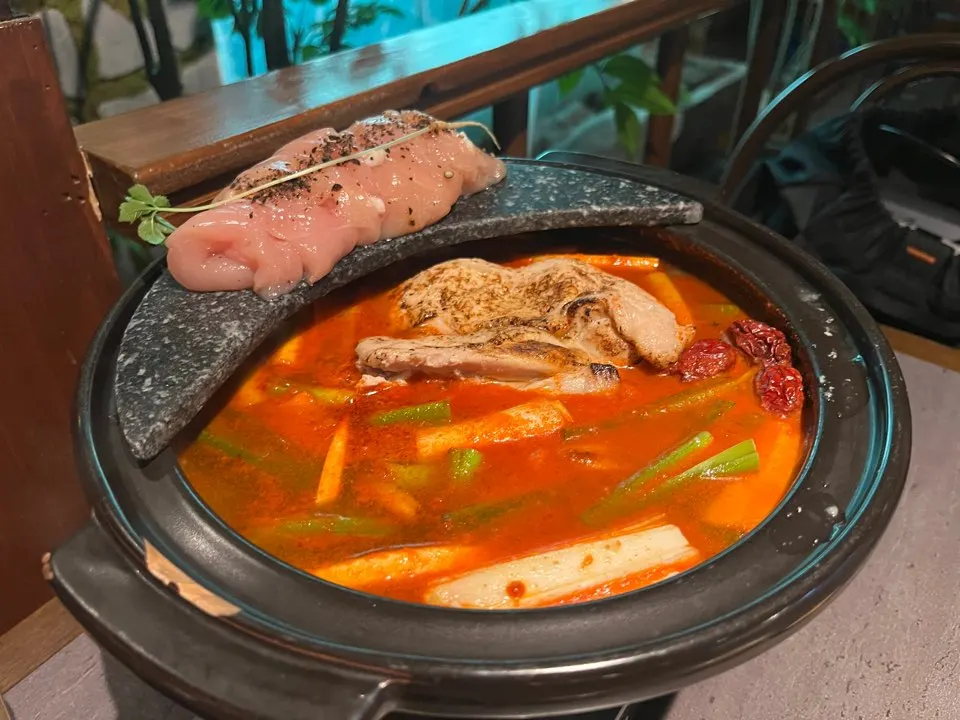 Chicken tenderloins on a stand with eomnamu branch in the hot pot