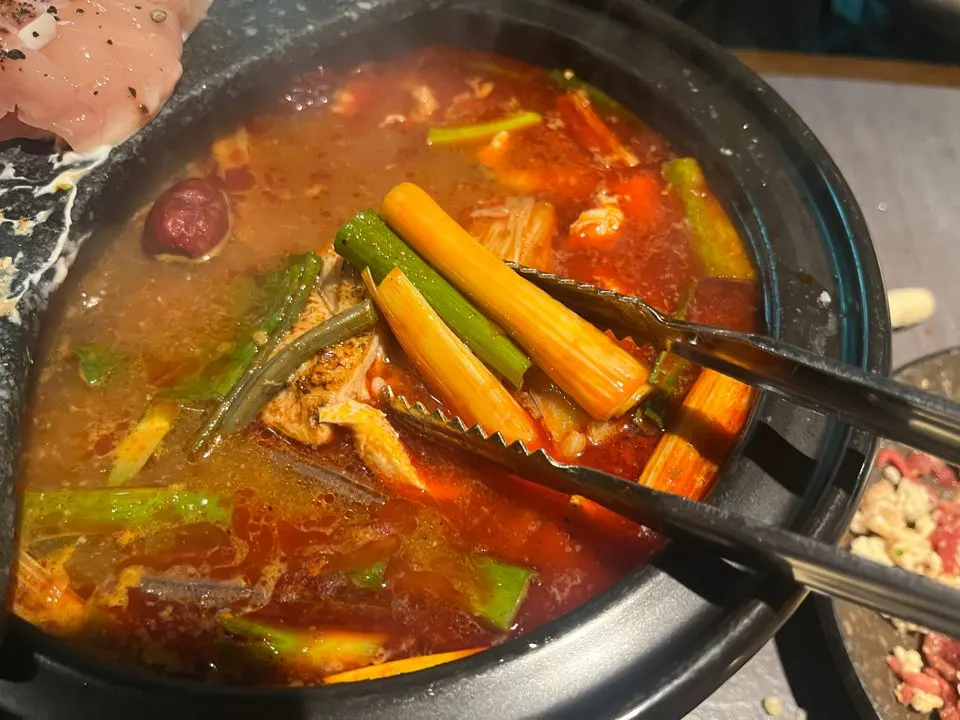 A ladle scooping up the hot pot broth
