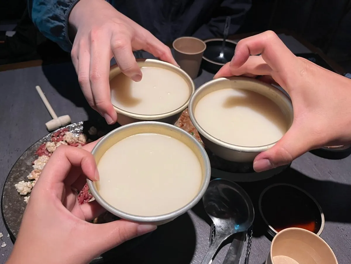 A poured glass of makgeolli beneath the valley interior