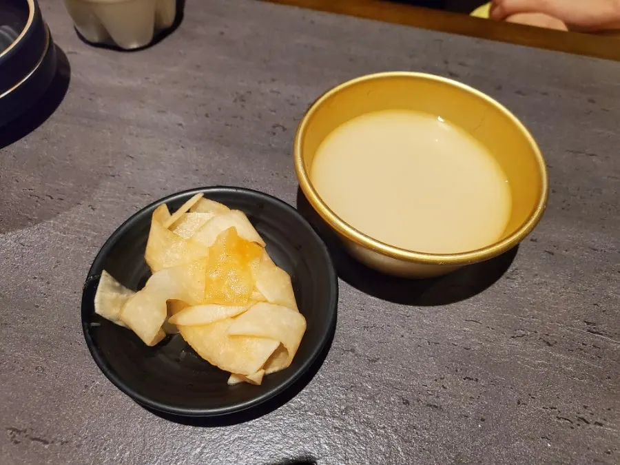 Makgeolli glass with the complimentary mu-chae side dish