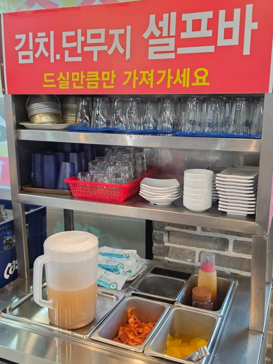 Self-serve bar with kimchi, pickled radish, and broth