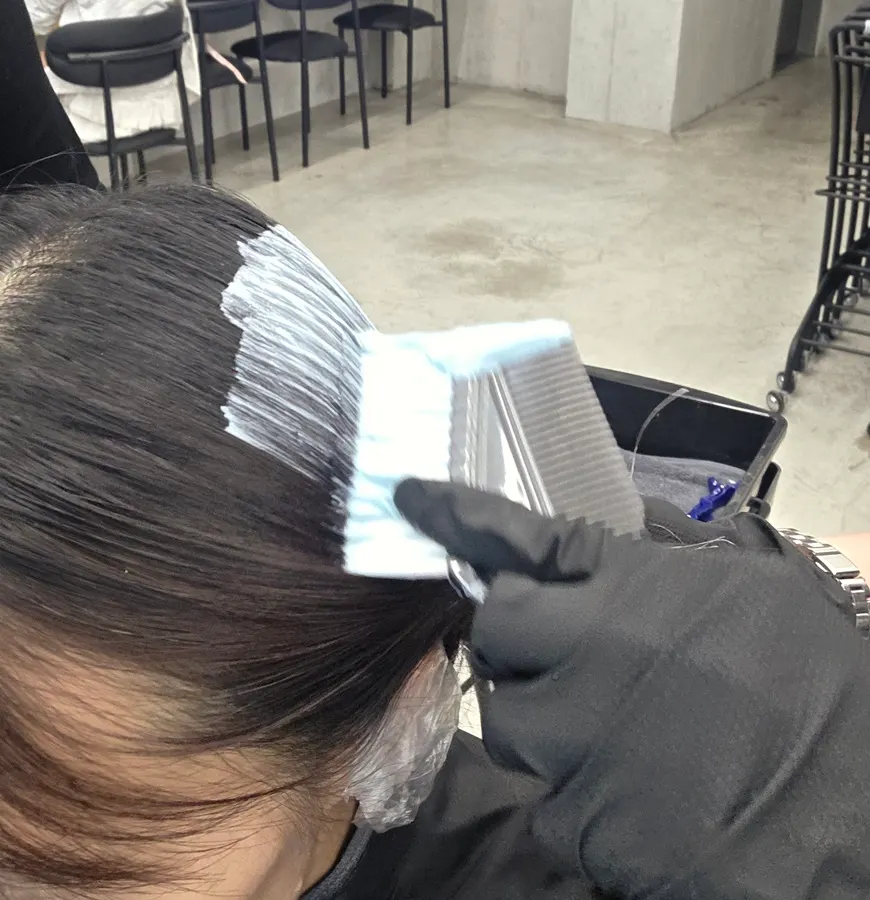 Ear covers on and scalp protectant being sprayed as prep