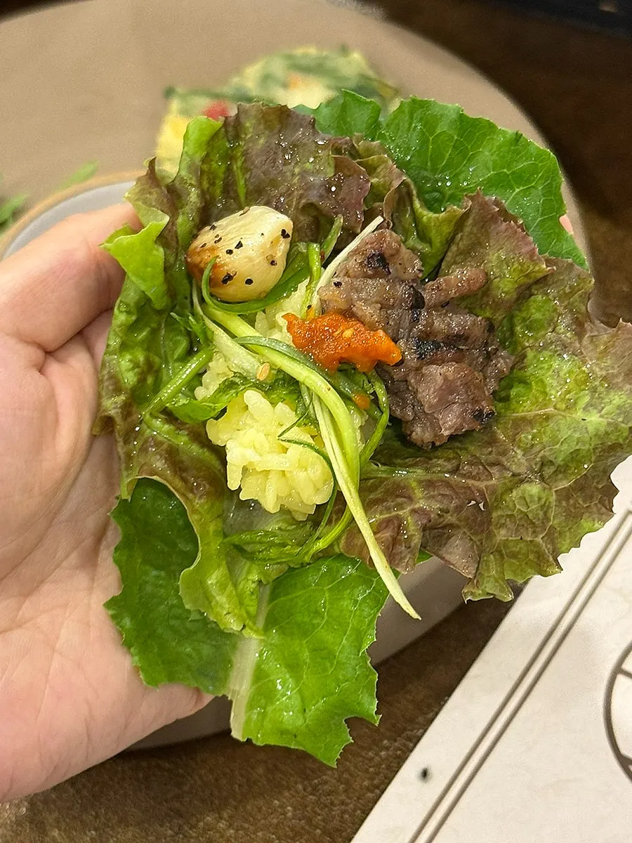 A tender piece of woo seokgalbi picked up with chopsticks