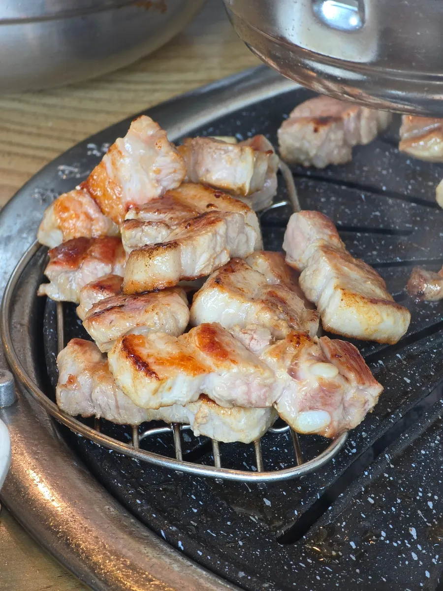 Pork belly and garlic grilling over charcoal