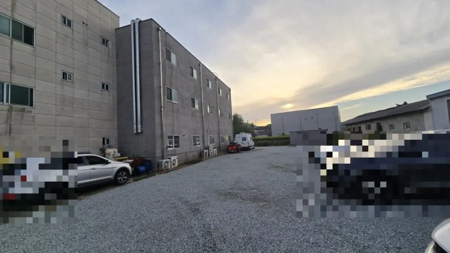 Wide gravel parking lot behind the building