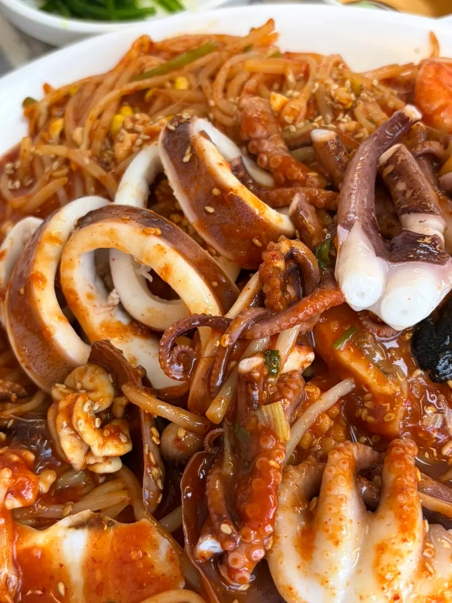 Plump shrimp and octopus visible in the seafood jjim