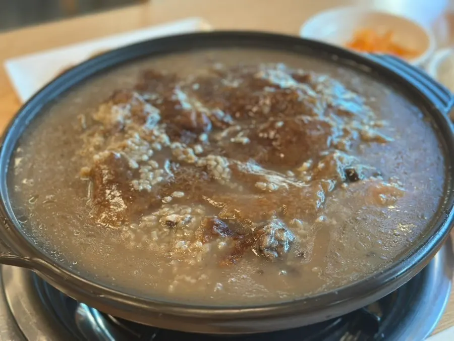 Earthenware pot of neungi nurungji duck baeksuk topped with scorched rice