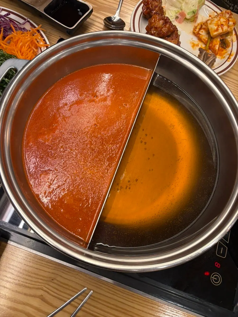 Two shabu-shabu broths prepared at the table