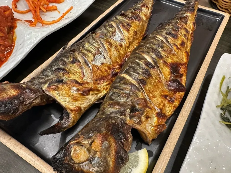 Table setting with grilled mackerel served alongside pot rice