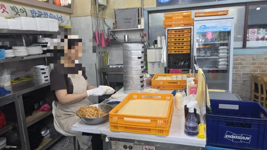 Staff hand-pinching dumplings in front of the kitchen
