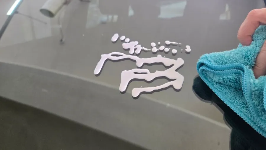 Car glass surface with the oil-film remover solution spread across it