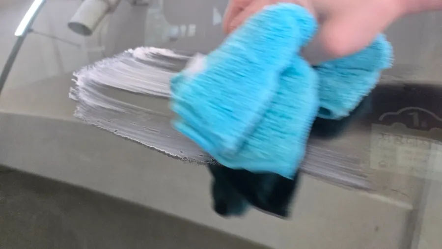 Wiping oil film from car glass with a towel