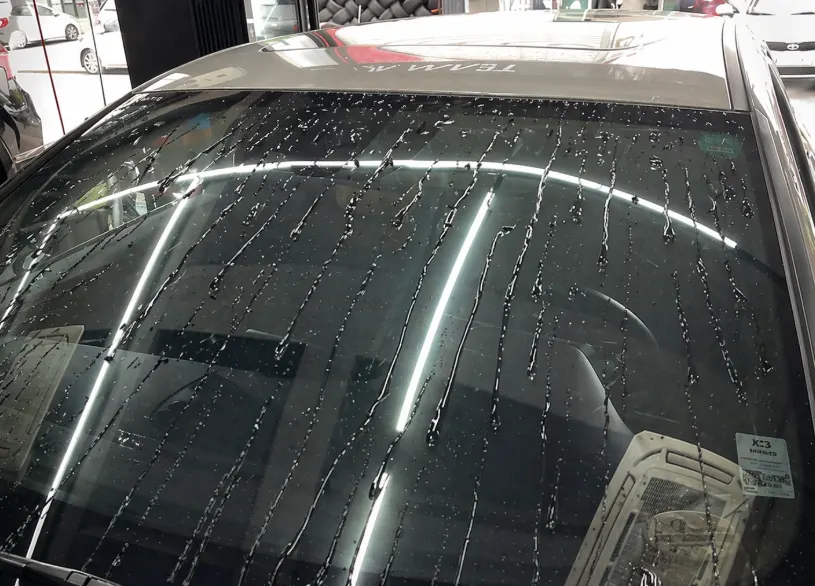 Vehicle glass rinsed with water after oil-film removal