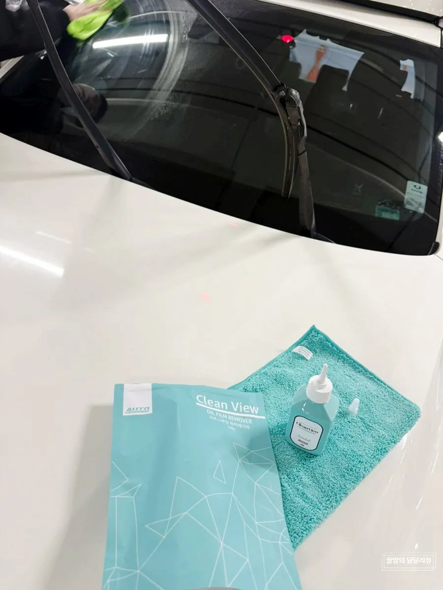 Car glass sprayed with solution to remove oil film