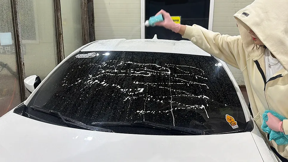 Wiping glass sprayed with oil-film remover using a towel
