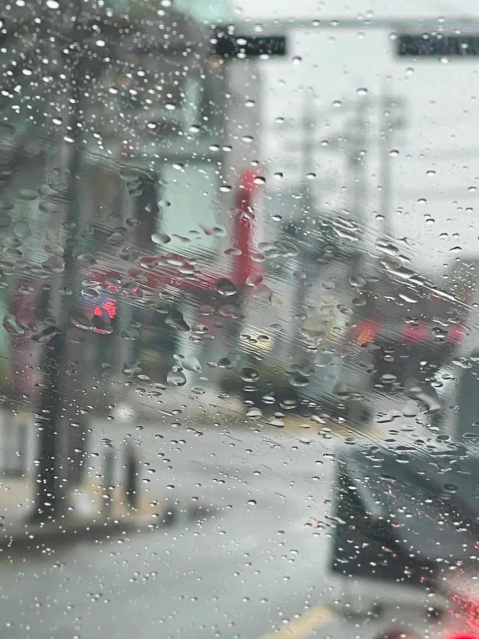 Car glass with a hazy film remaining on a rainy spring day