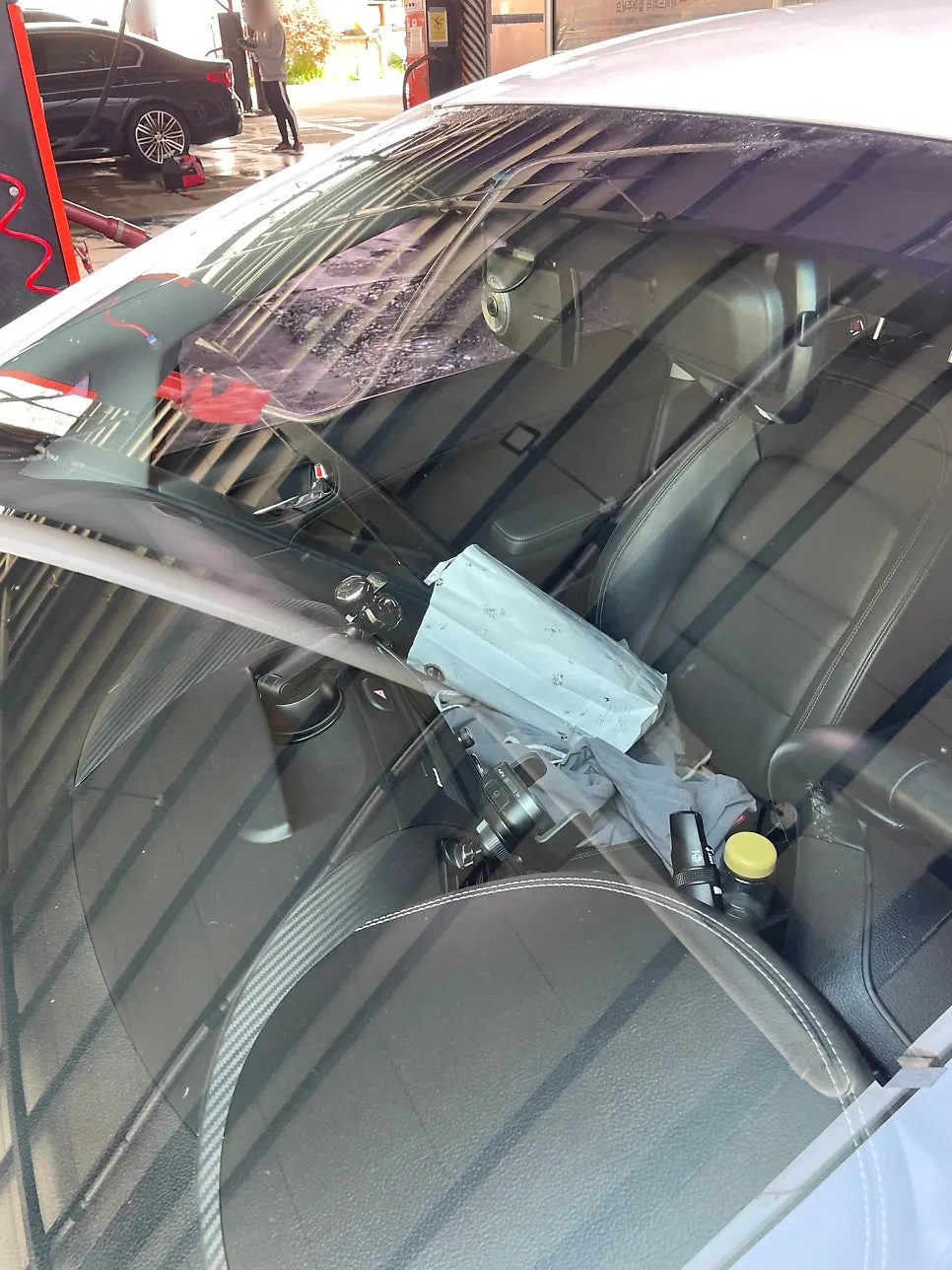 Car being rinsed with water after oil-film removal and a foam wash