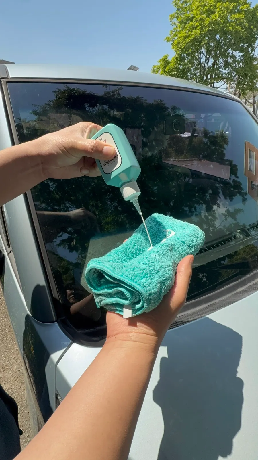 Wiping broadly across car glass with the dedicated towel