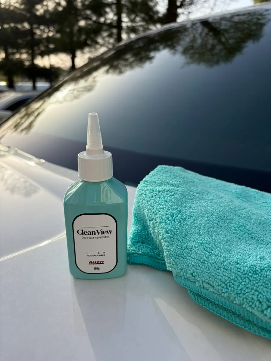 Rubbing oil film remover onto a car windshield
