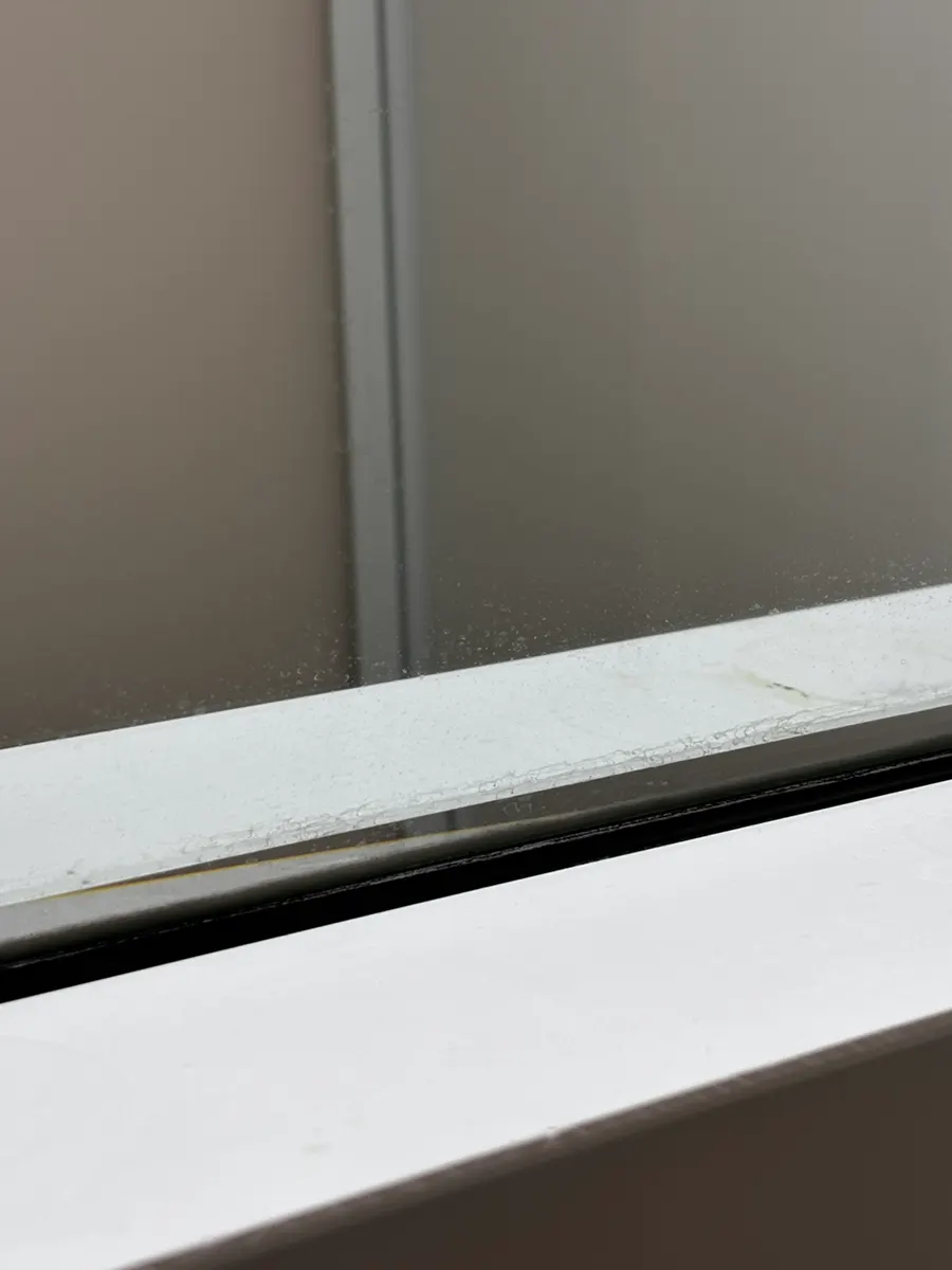Washroom glass surface with oil film remaining before cleaning