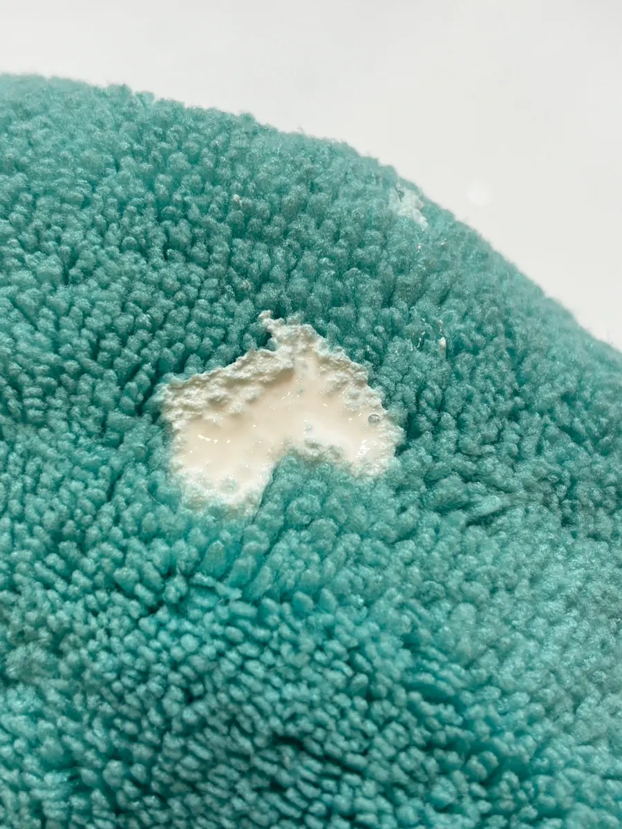Spreading oil-film remover over glass with the dedicated towel