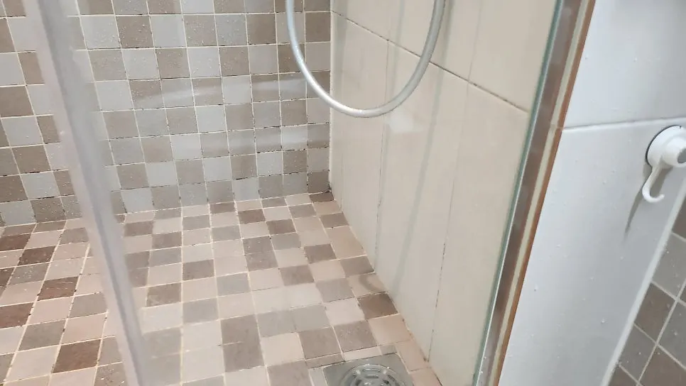 Wiping shower glass with film remover