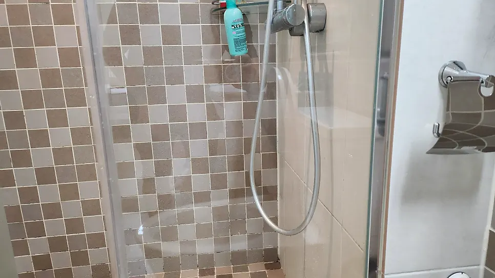 Tiles and shower head clearer behind the glass after rinsing