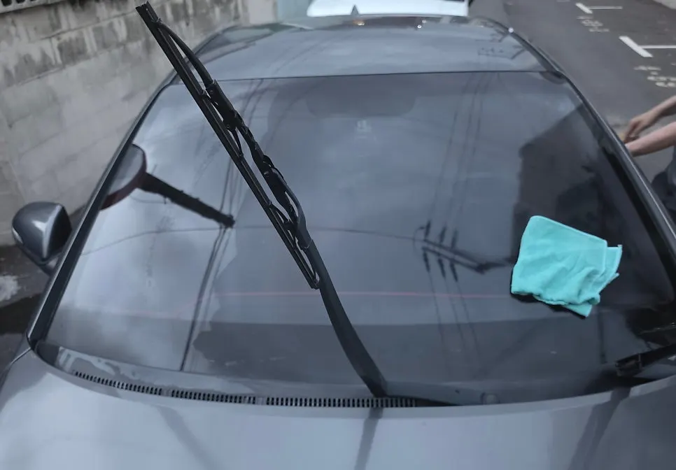 Car windshield showing water spread before and after oil-film removal
