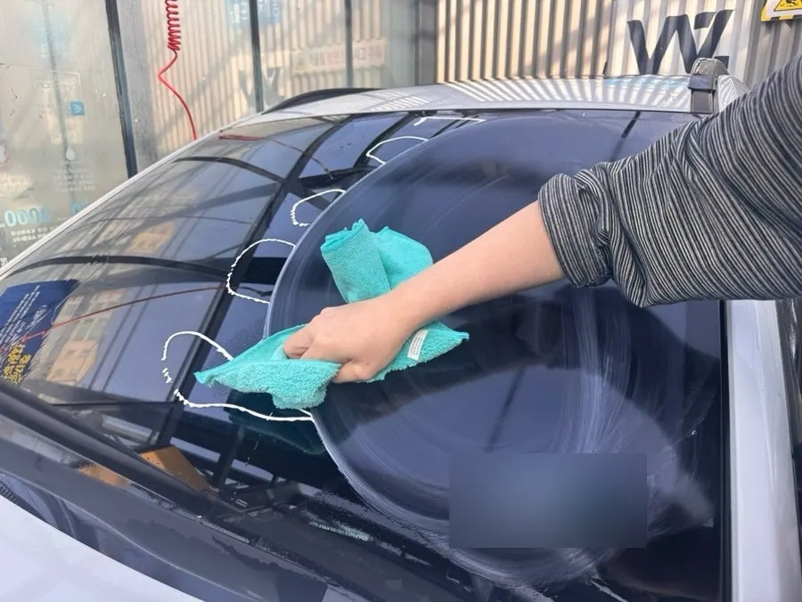 Applying oil film remover to a clean windshield