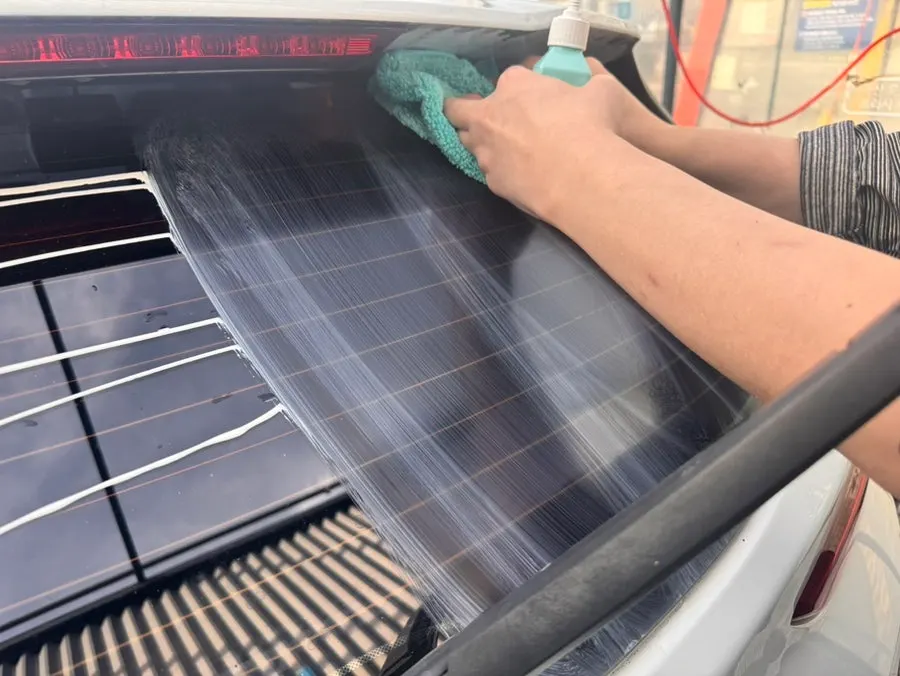 Wiping a windshield treated with oil film remover using a towel