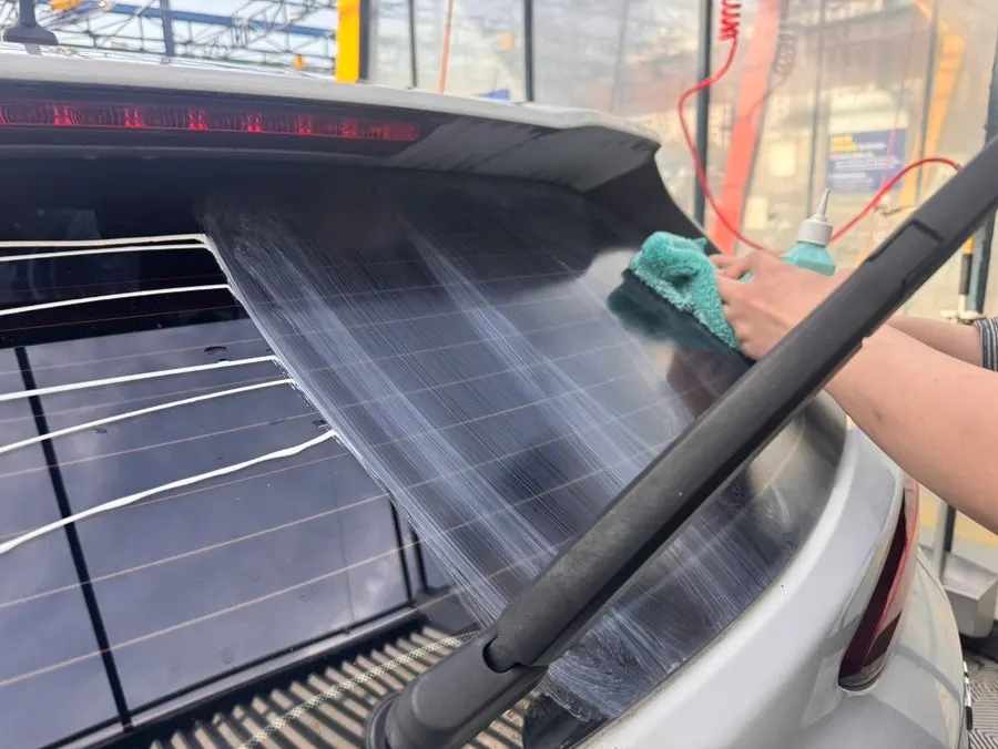 Rubbing the windshield with a towel in circular motions