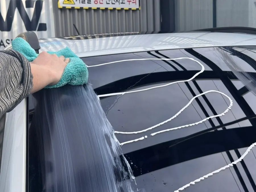 Rubbing the surface of car glass with a towel