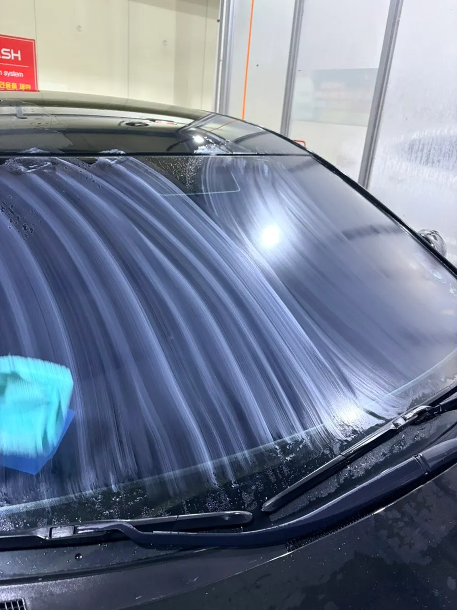 Applying solution to a car windshield that still has water on it