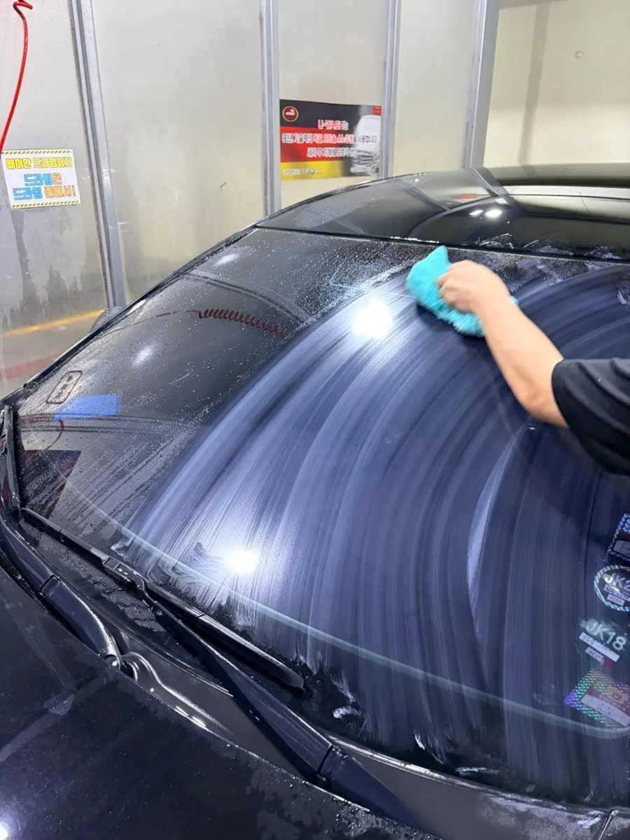 Working on a wet windshield at a self-service car wash