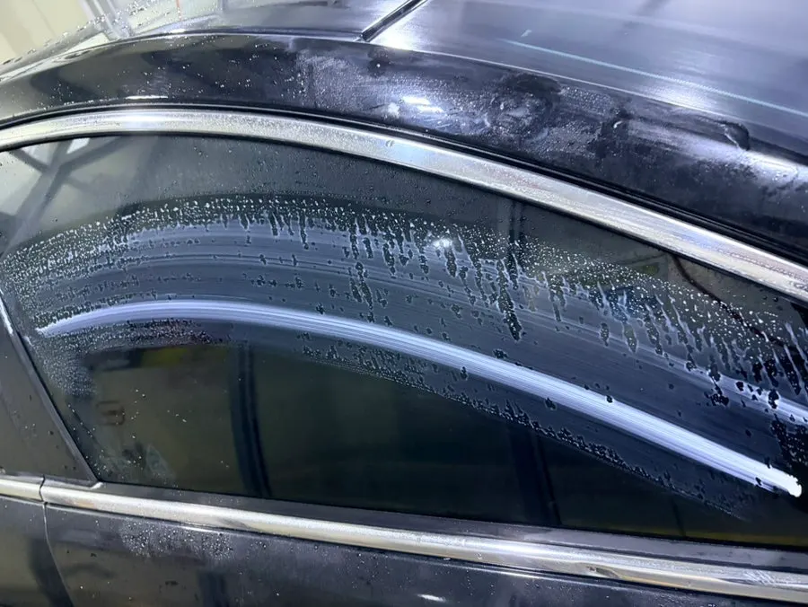 Rubbing a car glass surface with the dedicated towel