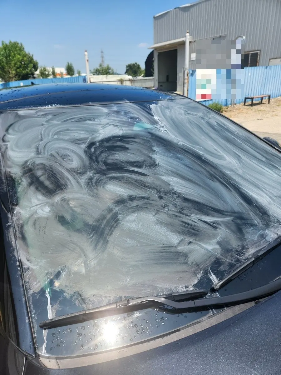 Rubbing oil-film remover into a car windshield