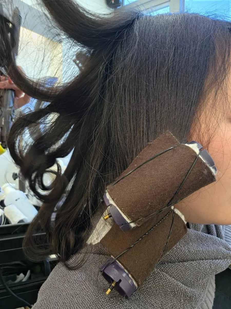 Hair smoothed with a flat iron after the rods