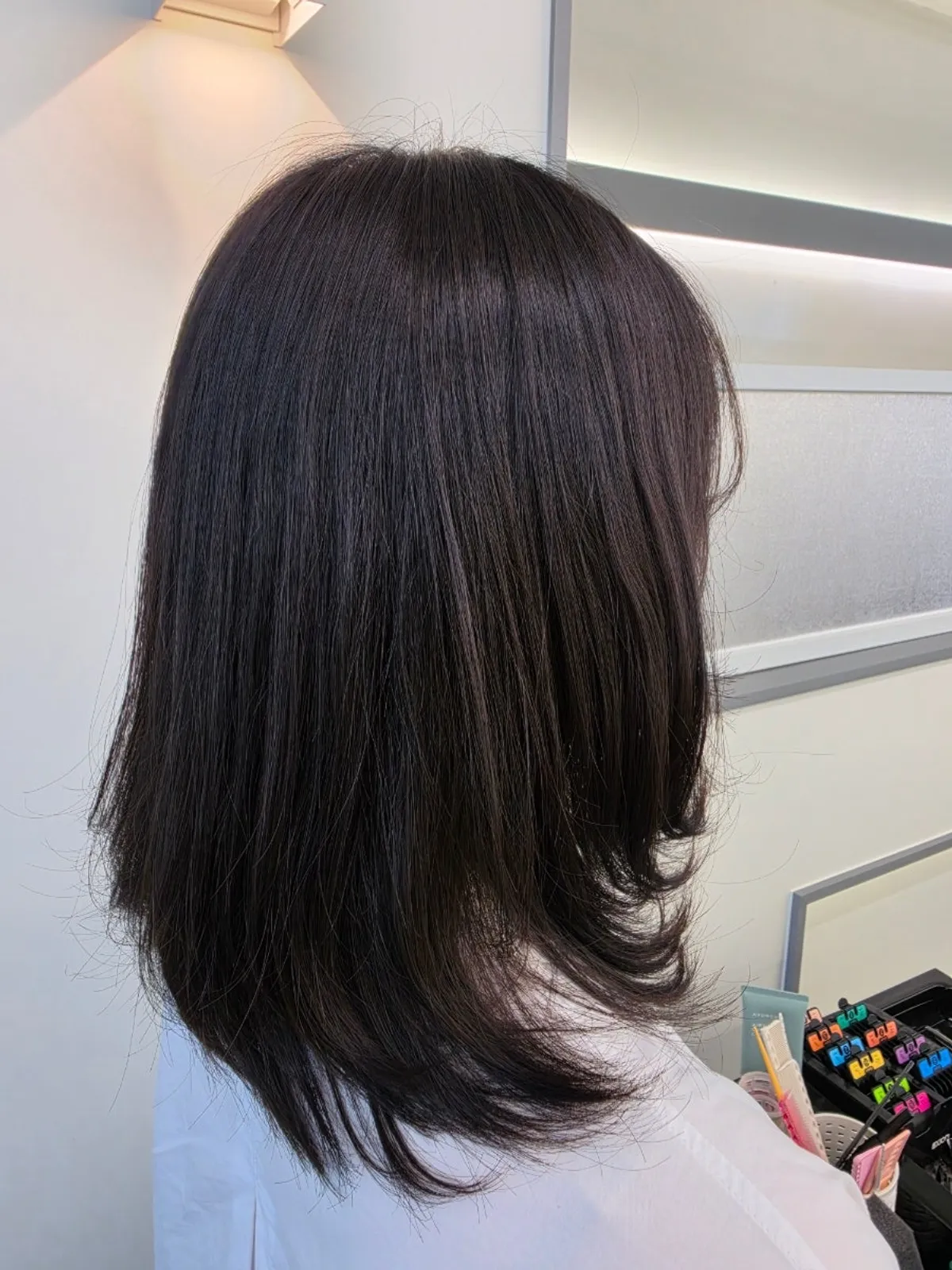 Bangs styled to cover the cheekbones with the C-curl perm