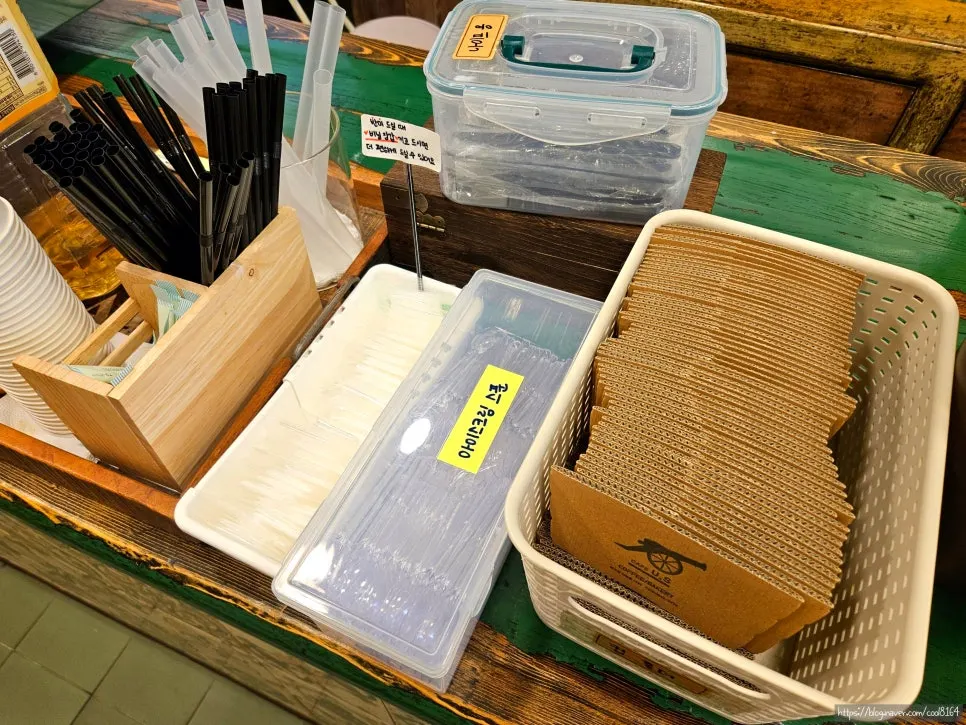Self-service corner with spoons, cup holders, and straws