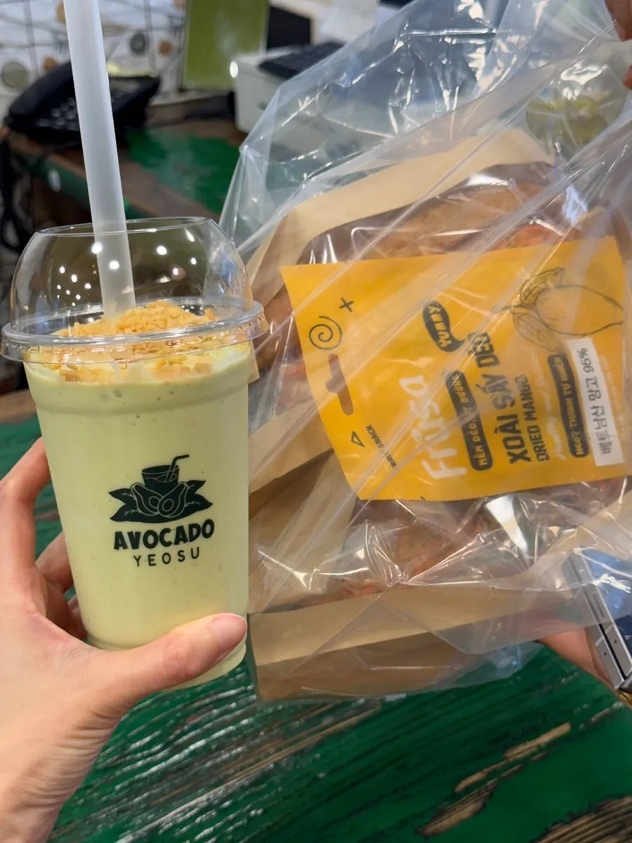 Avocado smoothie topped with coconut powder, served with banh mi