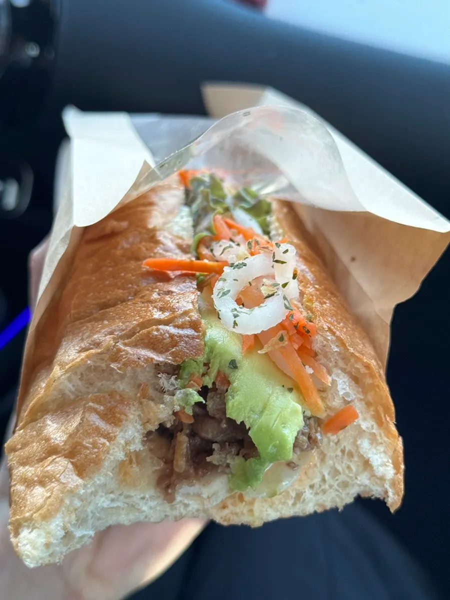 Cross-section of banh mi filled with sliced avocado and bulgogi