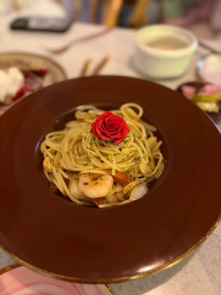 Rose aglio e olio topped with an edible rose