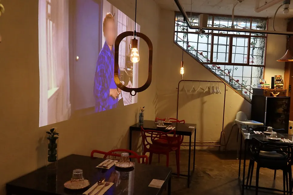 A selfie-zone seat in front of a wall with video playing