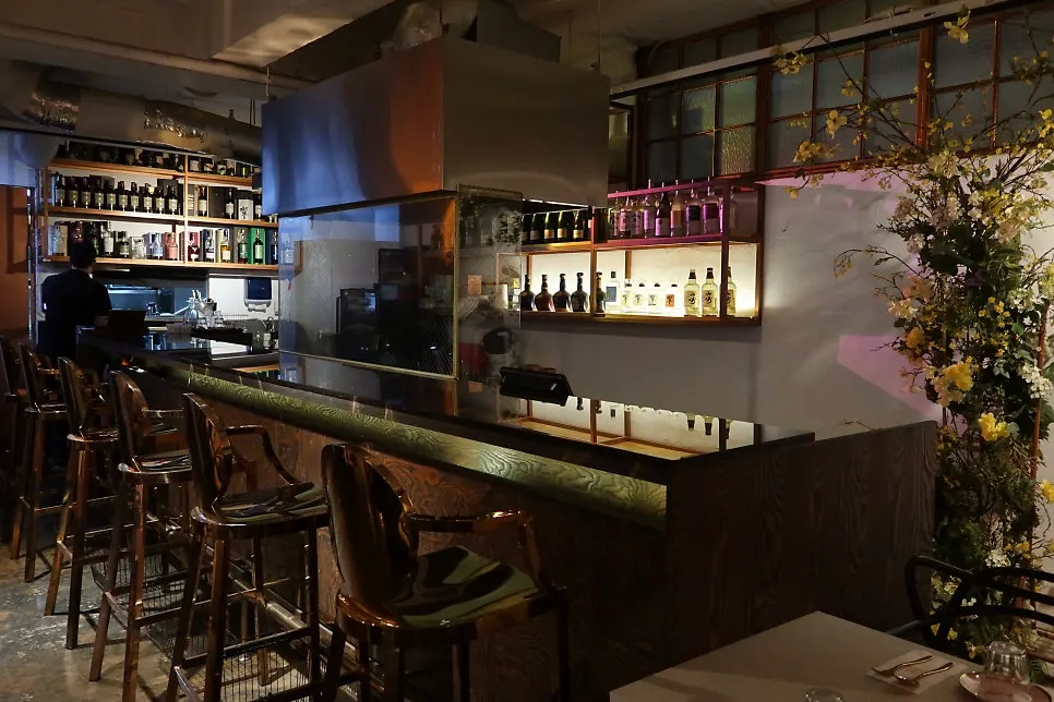 The bar area lined with liquor bottles and single seats