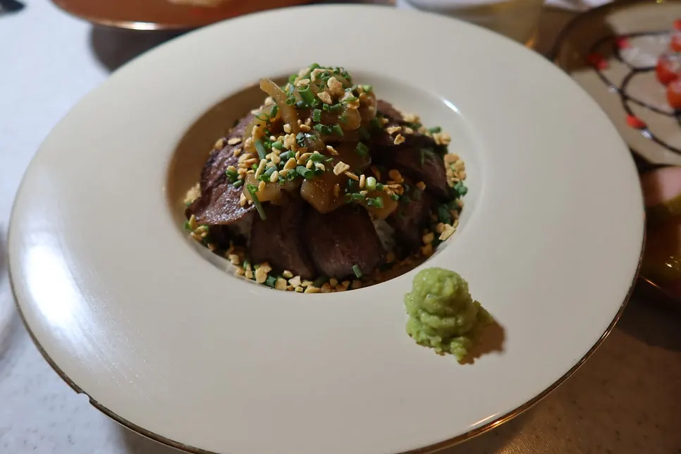 Close-up of the steak rice bowl with sauce and nuts