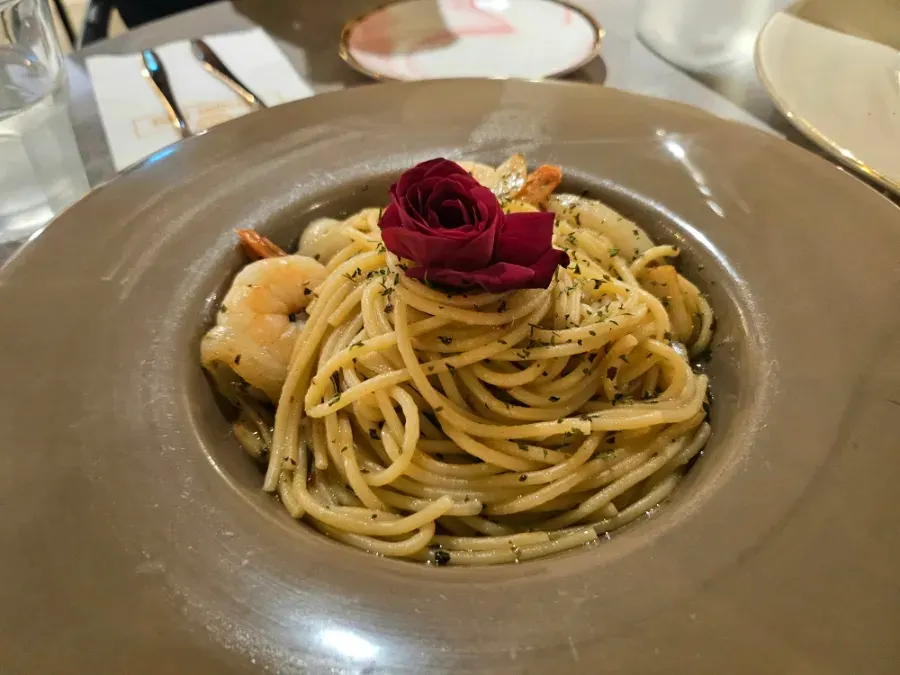 Rose aglio e olio topped with an edible rose